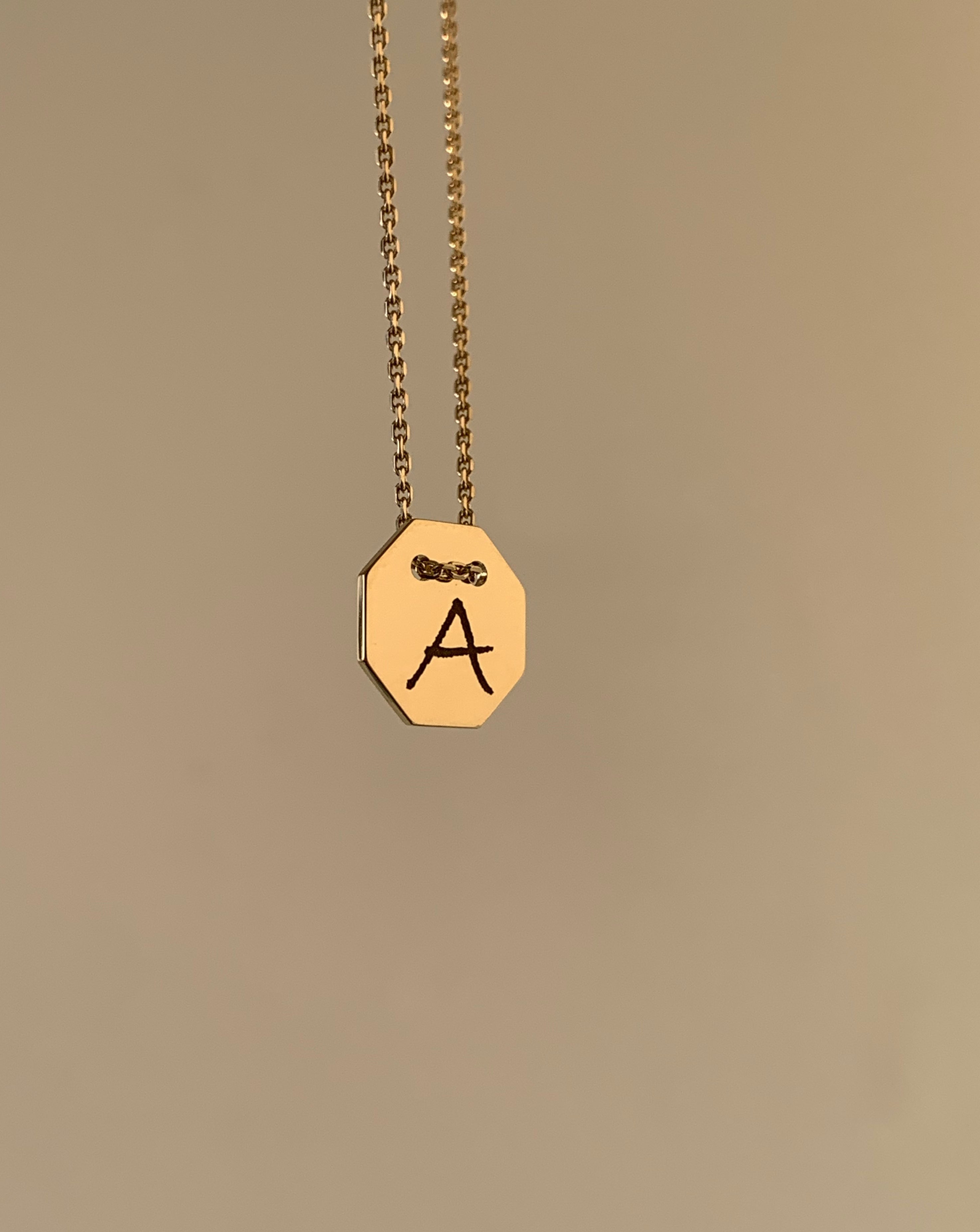 Medallón de letras en oro amarillo